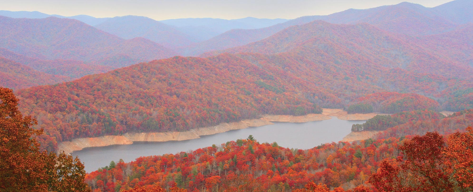 Red and orange trees cover the mountains during the fall at Smoky Mountains National Park in Tennessee 