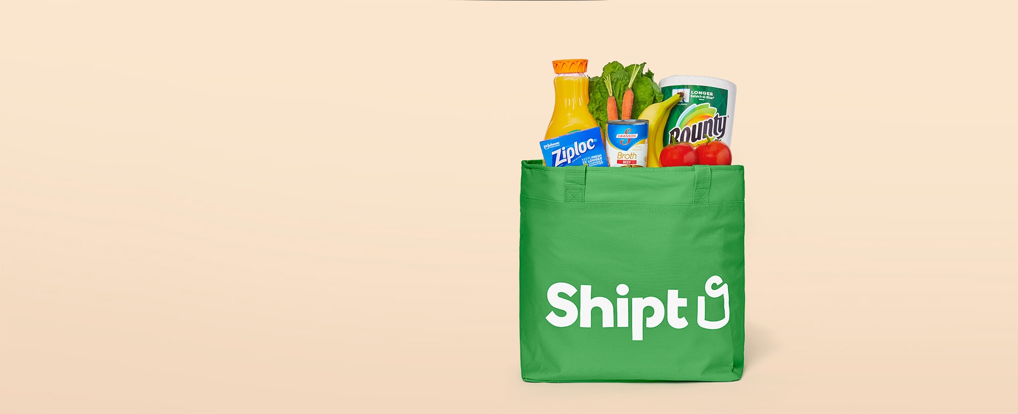 A bag featuring the Shipt logo, filled with groceries.