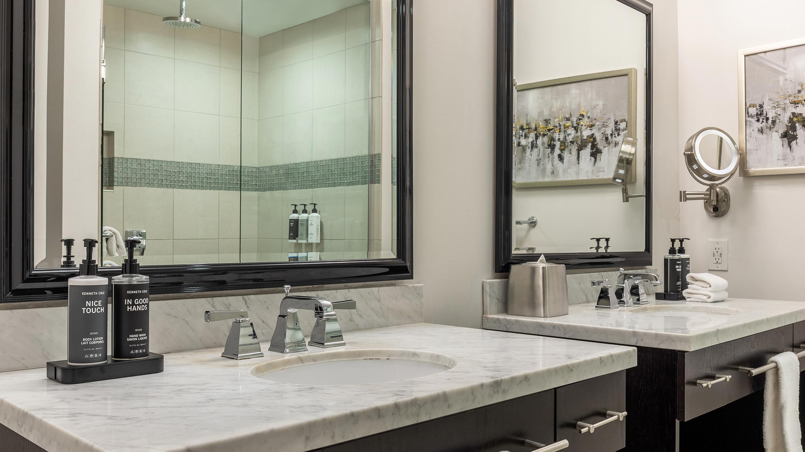 Bathroom in a Presidential Reserve suite with the new Kenneth Cole amenities on the countertop and in the shower, reflected in the mirror