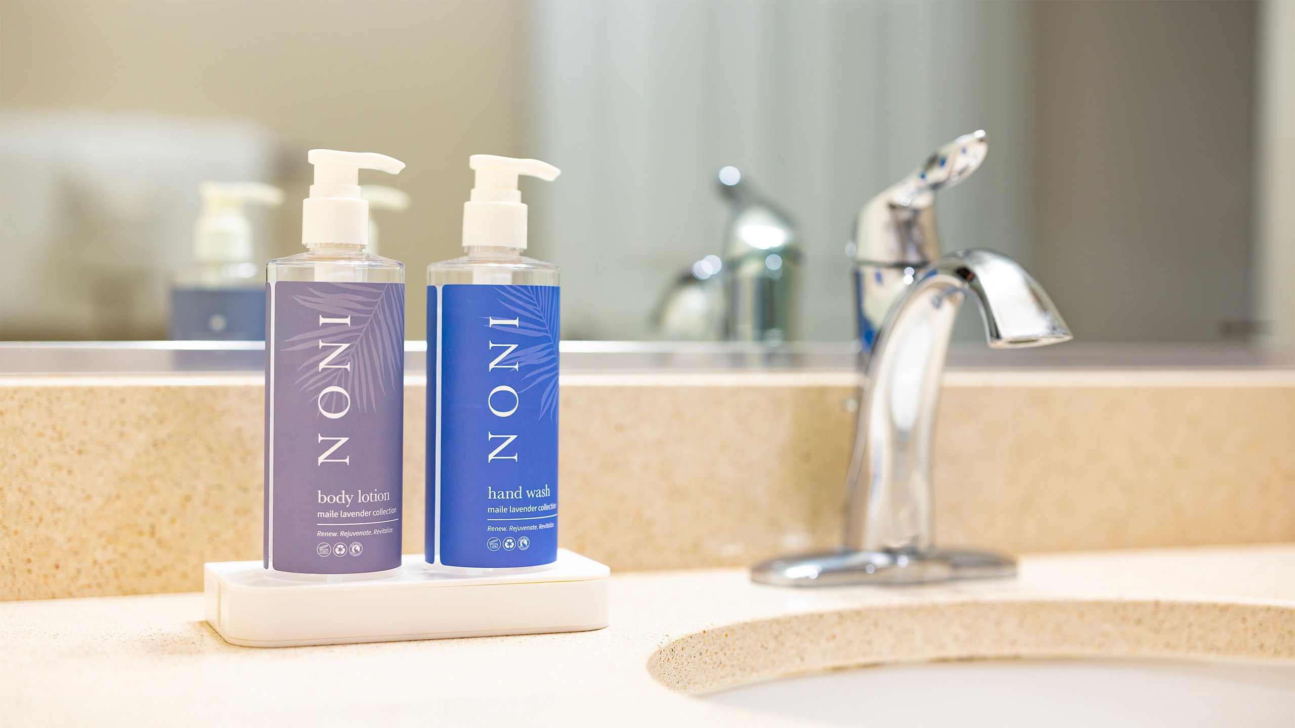 Two Noni bulk amenity bottles on the bathroom counter of a club resort in Hawaii