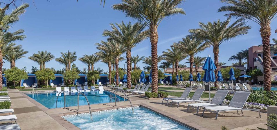 Blue chairs, umbrellas, and cabanas surround the pool and hot tub at Margaritaville Vacation Club by Wyndham - Desert Blue.