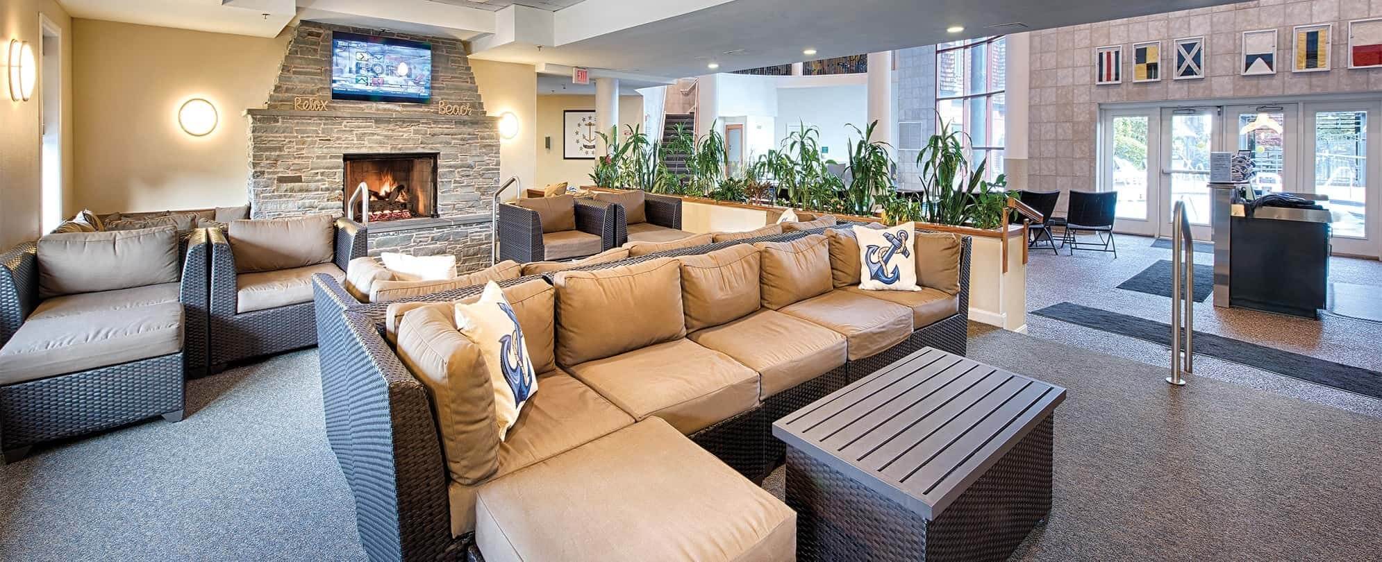 Wicker couches with tan cushions and fireplace in a Margaritaville Vacation Club by Wyndham resort lobby.