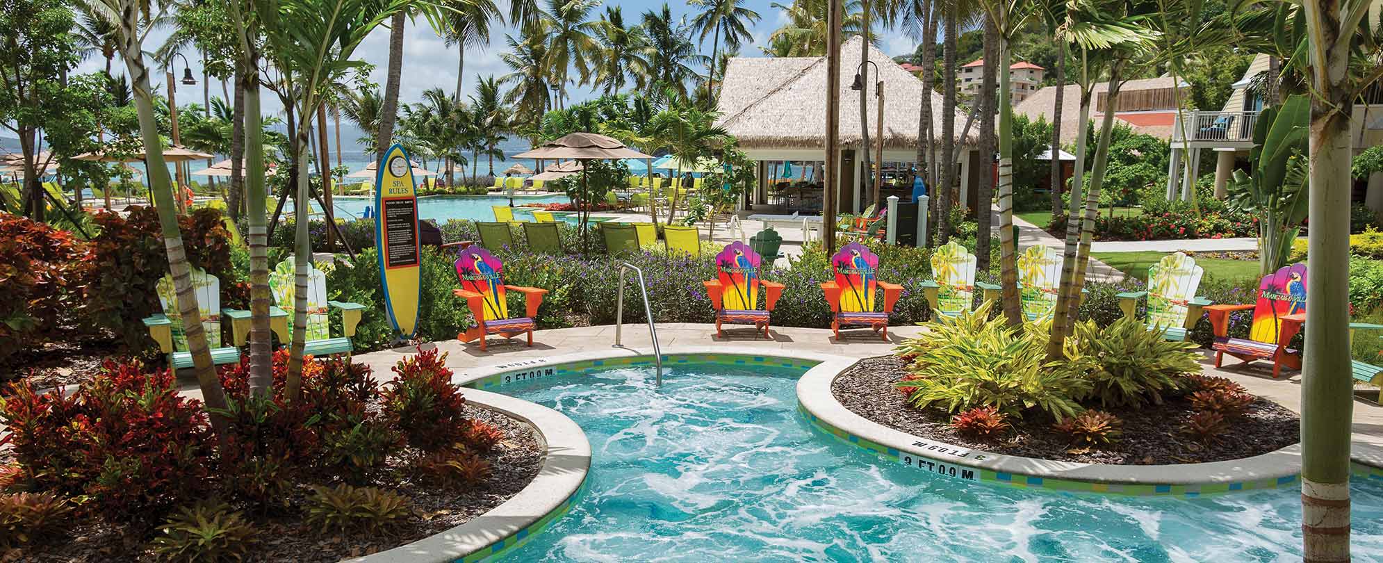 Colorful adirondack chairs surround a jetted hot tub at Margaritaville Vacation Club by Wyndham - St. Thomas.