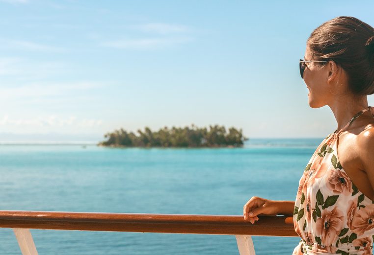 Cruise ship travel vacation luxury tourism woman looking at ocean from deck of sailing boat. Luxury Tahiti Bora Bora French Polynesia destination summer lifestyle.