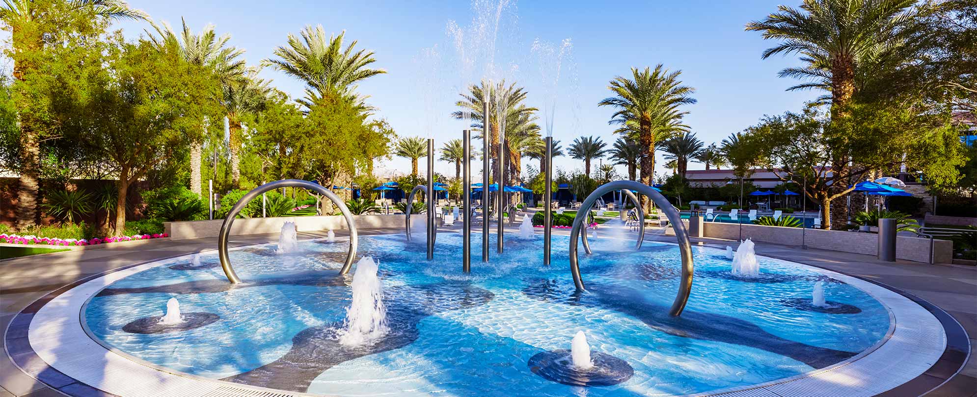 A large fountain pool surrounded by palm trees at Margaritaville Vacation Club by Wyndham - Desert Blue in Las Vegas, NV